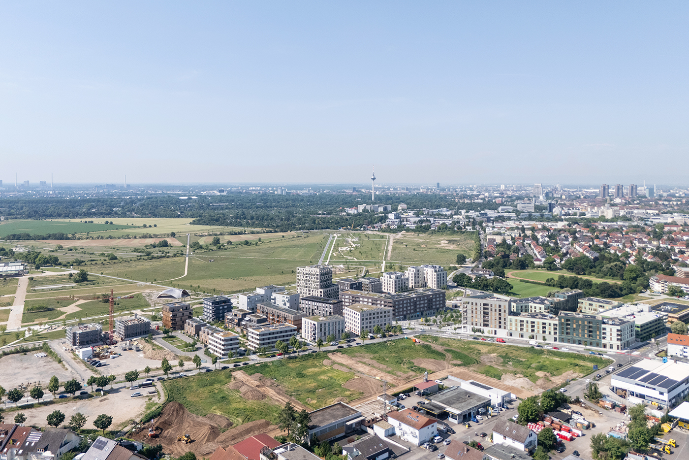 Drohnenaufnahme des SPINELLI Quartiers in Richtung SPINELLI Park. Im Vordergrund ist die noch unbebaute Fläche des Baufeld 3 sichtbar.